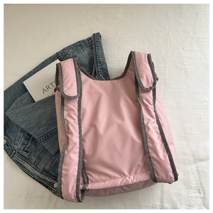 Detailed view of pink waterproof nylon backpack with grey trim and wide straps