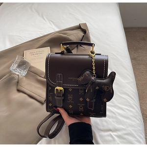 Detail of vintage bear monogram leather bag with teddy bear charm and metal buckle
