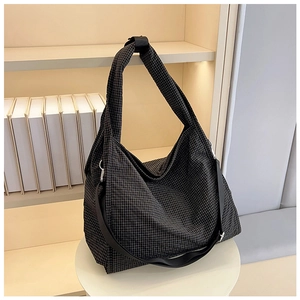 Detailed view of checkered canvas tote bag with adjustable strap on a display stand
