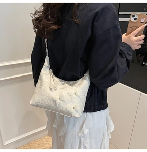 Détail du sac à bandoulière blanc avec broderies florales 3D et papillons décoratifs