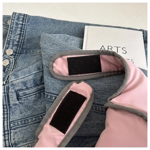 Detail of the pink fabric texture and black velcro closure on the vintage backpack