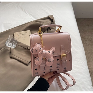 Detail of pink faux leather backpack with cartoon bear print and golden metal buckle