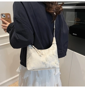 Détail du sac à bandoulière en dentelle blanche avec fleurs 3D et nœud de décoration