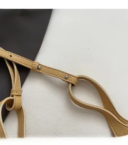 Detail of ginger lychee pattern leather shoulder strap with silver metal studs and stitching