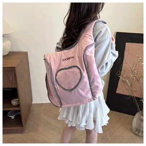 Close-up of pink puffer backpack featuring a heart pocket and fashion embroidery