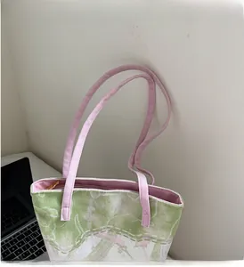 Detail of canvas bucket bag showing floral jacquard pattern and pink durable handles