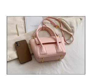 Pink PU leather crossbody bag size comparison with smartphone and decorative book