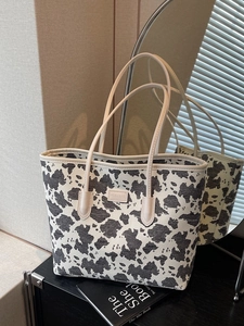 Minimalist cow print tote bag with black and white pattern and leather handles for women