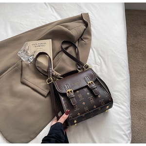 Detailed view of vintage brown leather bag with cartoon pattern and gold hardware