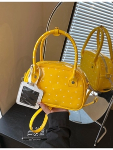 Chic bright yellow bowling bag with white heart patterns and adjustable shoulder strap
