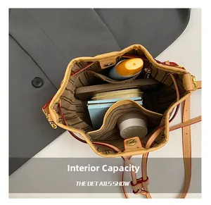 Internal capacity of khaki leather bucket bag showing striped lining and multiple pockets