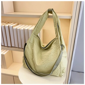 Detail of green plaid canvas tote bag with adjustable strap and silver metal hardware