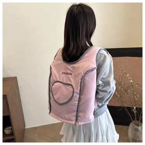 Detail of pink padded nylon vest backpack showing Fashion embroidery and heart pocket