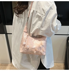 Detailed view of pink shoulder bag with lace fabric and 3D mesh butterfly embellishments