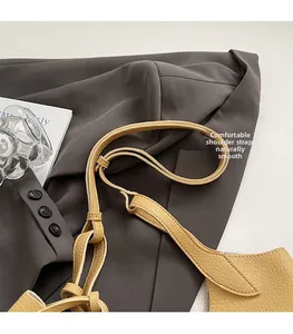 Detail of yellow lychee pattern leather shoulder strap with durable metal buckle