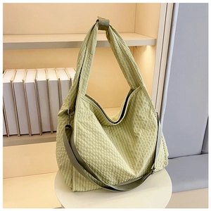 Detail view of light green gingham canvas tote bag with adjustable crossbody strap