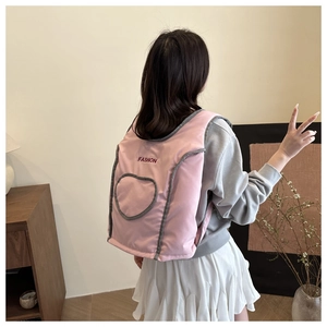 Close-up of pink quilted vest featuring Fashion embroidery and circular grey piping detail