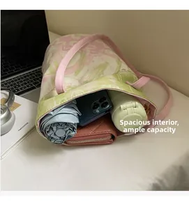 Detail view of large capacity floral tote bag showing umbrella, phone, and wallet inside