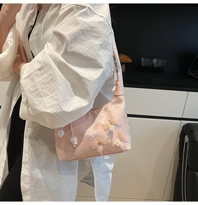 Détail du sac à bandoulière en soie rose avec broderie et papillons en maille