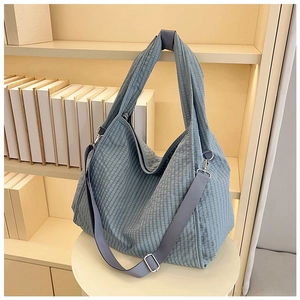 Detail of grey-blue plaid canvas tote bag showing adjustable wide shoulder strap and metal hooks