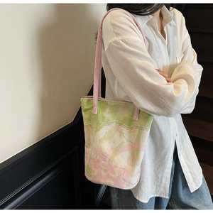Floral canvas tote bag with pink straps worn by a model in casual style