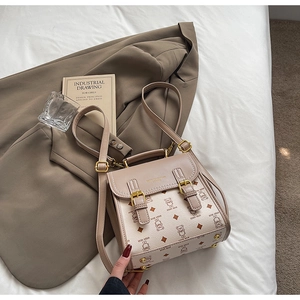 Detail of cream leather backpack with teddy bear print on a white fabric background