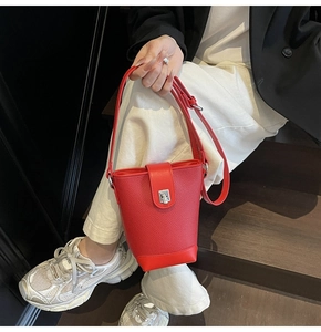 Detail of red lychee grain leather bucket bag with silver buckle and adjustable strap