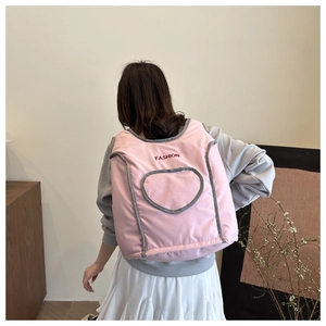 Pink quilted backpack detail showing heart stitching and fashion embroidery