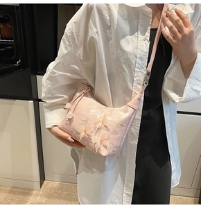 Detail of pink lace handbag featuring 3D silk butterflies and a delicate pearl pendant