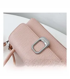 Detail of pink handbag featuring wavy texture and rectangular silver buckle decoration