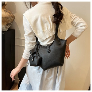 Chic black bucket bag with lychee texture and coin pouch shown in a lifestyle setting