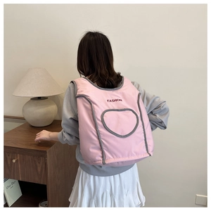 Detailed view of pink nylon backpack featuring an embroidered FASHION logo and heart pocket