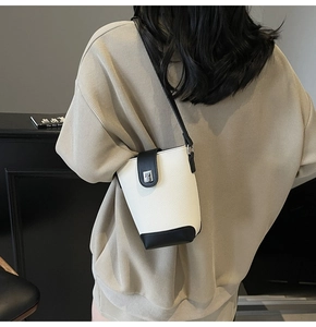 Detail view of contrast shoulder bucket bag in black and white leather with strap