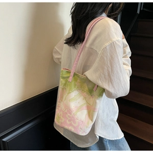 Detailed side view of floral canvas tote bag showing green and pink artistic patterns