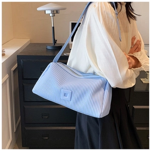 Detail of light blue pleated shoulder bag with soft leather texture and zipper closure