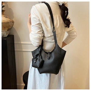 Detail of black pebbled leather bucket bag with matching mini pouch and decorative buckle