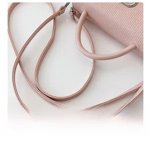Detail of adjustable shoulder strap and textured wave-pattern leather on pink handbag