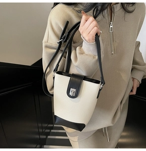 Close-up of contrast bucket bag in lychee texture faux leather with silver metal lock