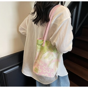 Detailed view of floral canvas bucket bag with pink shoulder straps and HOOG logo label