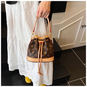 Detail of vintage bucket bag featuring MQ monogram print and drawstring closure