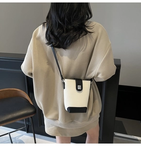 Minimalist white lychee leather bucket bag with black contrast trim and metal buckle
