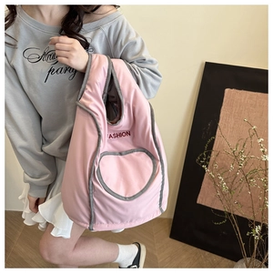 Detail of pink puffy backpack with red FASHION text and grey heart stitching accent