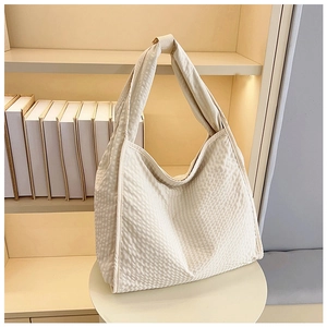 Macro shot of cream waffle fabric texture on a minimalist canvas hobo shoulder tote bag