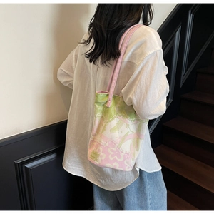 Detailed view of the jacquard floral bucket bag with pink handles and HOOG branding