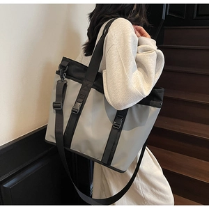 Detail of gray and black large capacity tote bag with functional buckle straps and handle