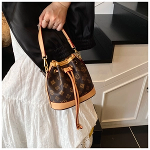Detailed view of mini bucket bag showing drawstring closure and vintage monogram pattern
