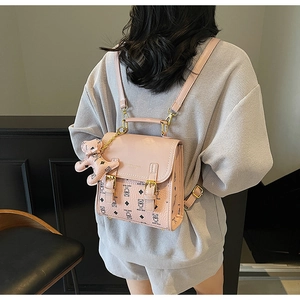 Pink PU leather backpack featuring cartoon bear print and stylish metallic hardware