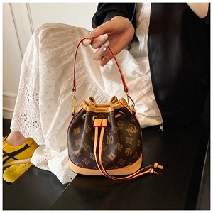 Detail of vintage bucket bag with MQ floral monogram and vibrant red shoulder strap