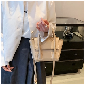 Detail of beige structured PU tote bag with double handles and rectangular stitching