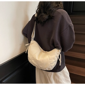 Rear view of model wearing cream oversized crescent crossbody bag in soft nylon